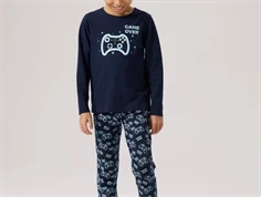 Barn iført mørkeblåt pyjamassæt fra Name It med gamer-motiv